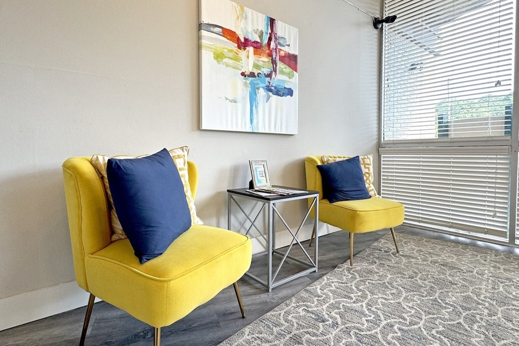a living room with two yellow chairs and a table and a window at Spring Lake Cove Apartments, Birmingham, AL
